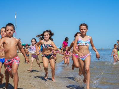 Enfants courant joyeusement sur la plage par une journée d'été.