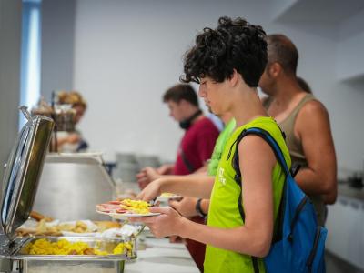 Des jeunes en file au buffet, se servant eux-mêmes.