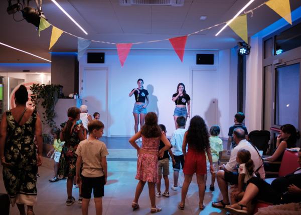 Spettacolo per bambini con animatori su un palco.