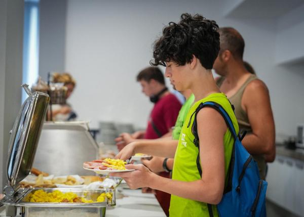 Des jeunes en file au buffet, se servant eux-mêmes.